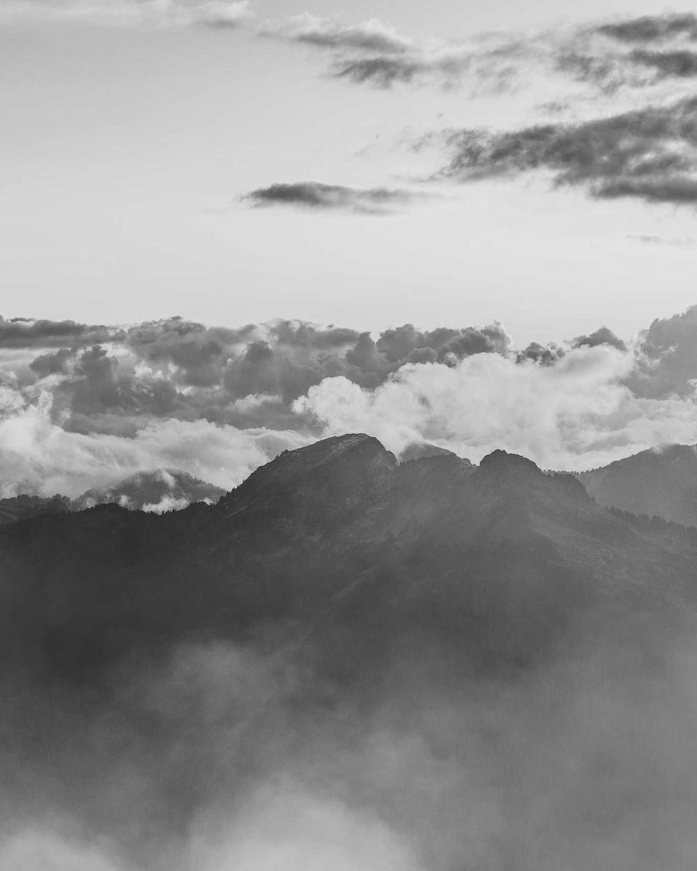 Berggipfel über einer Wolkendecke in Schwarzweiß